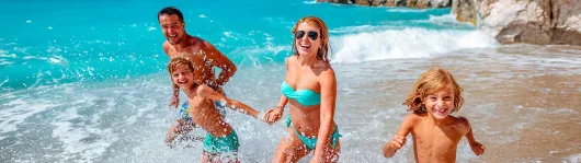 familienurlaub-glueckliche-familie-im-wasser-1600x450